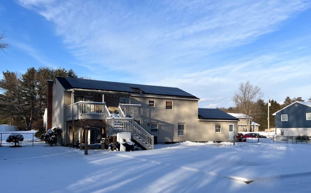 House in winter with solar panels on roof