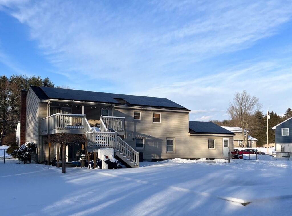 House in winter with solar panels on roof